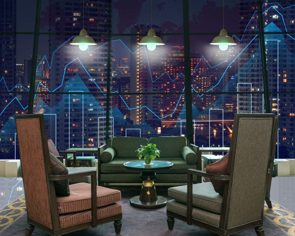 Lobby area of a hotel which can see Trading graph on the cityscape at night and world map